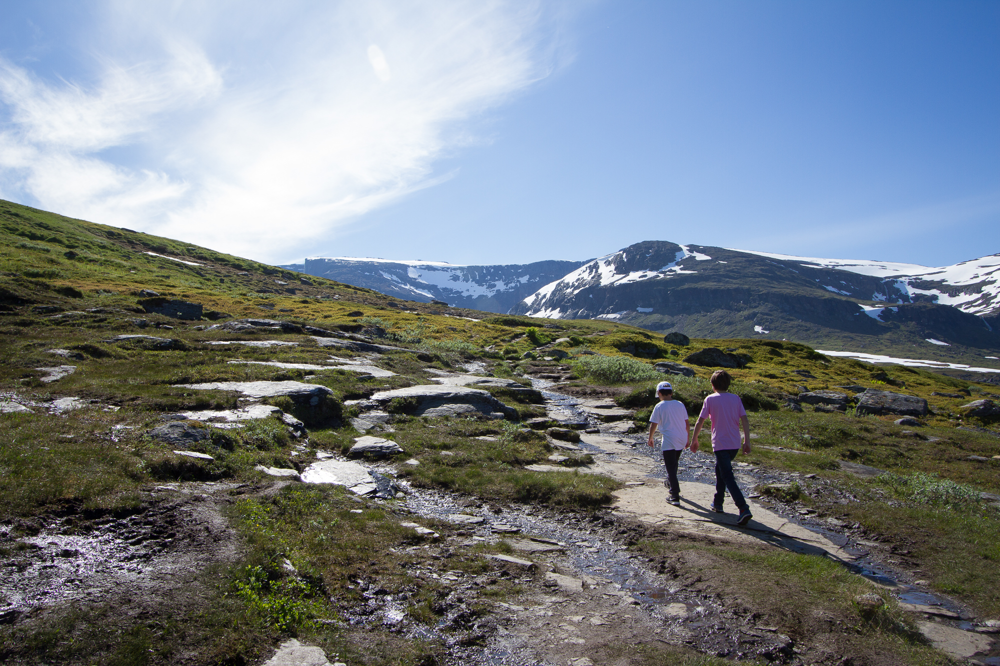 Two kids walking the Kärkevagge trail, Swedish Lapland. Mount Vassitjåkka in the background.